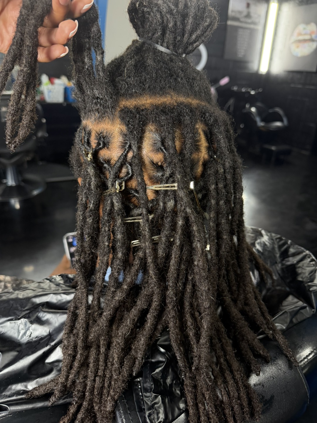 A retwist part-way through, the freshly parted sections held in clips while the rest is still to be done